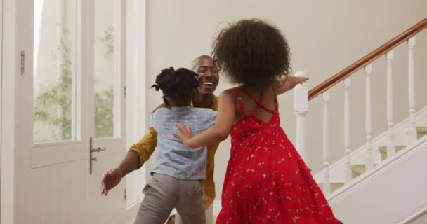 一个非裔美国人走进他家的前门 和他的家人一起站在大厅里 慢吞吞地问候和拥抱着 — 图库视频影像