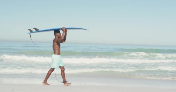 Afroamerykanin Wakacjach Spacerujący Słońcu Tropikalnej Plaży Trzymający Deskę Surfingową Głowie — Wideo stockowe