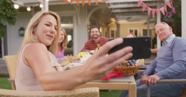 Kaukasische Mehrgenerationenfamilie Verbringt Zeit Garten Sitzt Esstisch Benutzt Ein Smartphone — Stockvideo