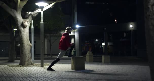 夕方には公園で運動をする若い運動選手の白人男性が ヘッドライトのついたベンチに腰を下ろしていた 健康的な都市生活 — ストック動画