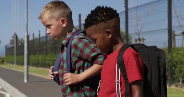 複数の子供の歩行者の交差点には 道路を横断する民族グループは スローモーションで 自分の学校の袋を運ぶ 小学生 道路安全 — ストック動画