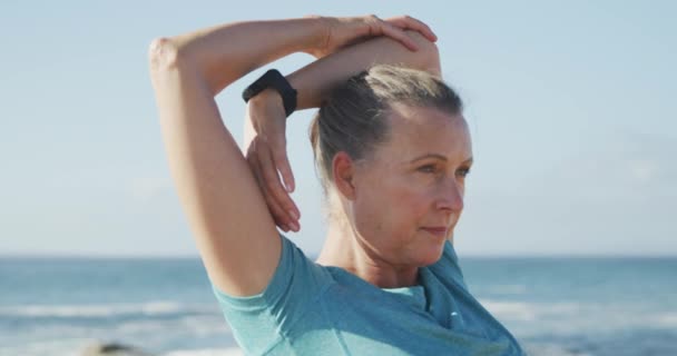 スポーツウェアを着て公園で働くシニアフィット白人女性は 彼女の腕を伸ばします 退職健康的なライフスタイル活動 — ストック動画