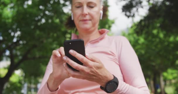 Idősebb Fehér Edz Parkban Sportruhában Ellenőrzi Okostelefonját Mielőtt Lassított Felvételen — Stock videók