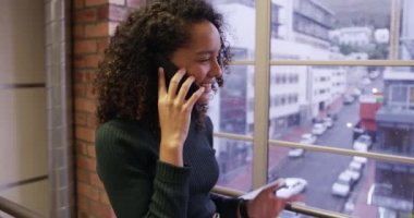 Modern bir ofiste çalışan, akıllı telefon kullanan, telefonla konuşan, gülümseyen ırktan profesyonel bir iş kadını. İş yaratıcılığı teknolojisi.