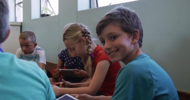 一个白人男孩和他的同学在教室里坐在地板上 看着相机 慢动作的画像 小学的教育 — 图库视频影像