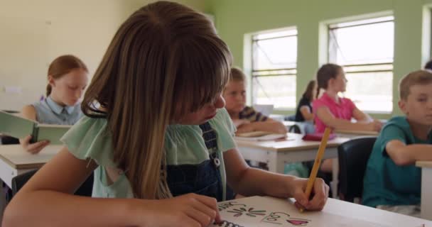 Кавказька Дівчинка Сидить Столом Класі Малює Блокноті Однокласниками Задньому Плані — стокове відео