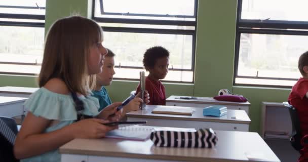Мультиэтническая Группа Детей Сидящих Классе Время Урока Поднимая Руки Замедленной — стоковое видео