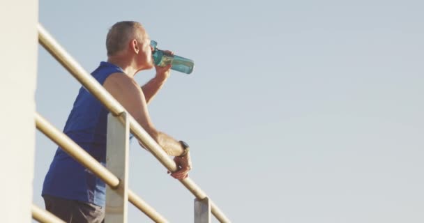 Idősebb Fehér Férfi Aki Tengerparti Sétányon Edz Sportruhában Szünetet Tart — Stock videók