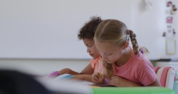 授業中に教室に座っている白人の女の子の肖像画は カメラを見て笑顔で 背景に同級生と スローモーションで 小学校での教育 — ストック動画
