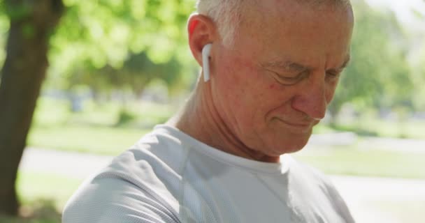 Kıdemli Beyaz Adam Parkta Spor Kıyafetleriyle Çalışıyor Kulaklığı Takıyor Ağır — Stok video