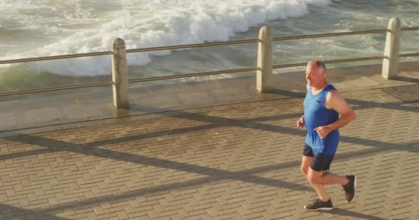 Kıdemli Beyaz Adam Deniz Kenarındaki Gezinti Güvertesinde Spor Kıyafetleriyle Çalışıyor — Stok video