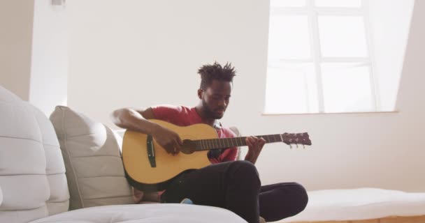 Змішана Раса Чоловік Розслабляється Вдома Вихідних Сидить Дивані Грає Гітарі — стокове відео