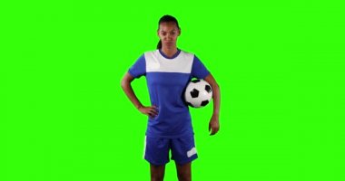 Spor kıyafetleri giymiş, elinde kameraya bakan kendine güvenen kadın futbolcu portresi. Sporcu gücü