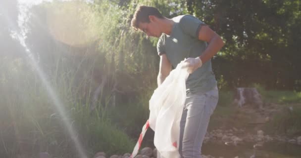 Voluntario Masculino Caucásico Limpiando Río Día Soleado Campo Recogiendo Basura — Vídeos de Stock