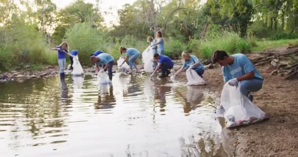 Egy Többnemzetiségű Boldog Természetvédelmi Önkéntesek Csoportja Akik Feltakarítanak Egy Folyót — Stock videók