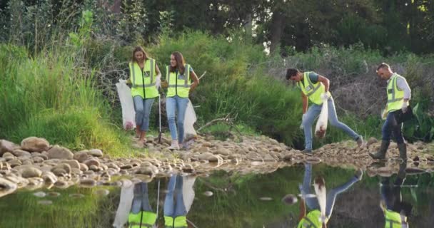 Eine Multiethnische Gruppe Von Naturschützern Mit Warnwesten Säubert Einen Fluss — Stockvideo