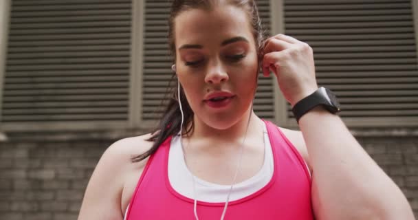 Uzun Siyah Saçlı Spor Kıyafetleri Giyen Şehirde Egzersiz Yapan Kulaklık — Stok video
