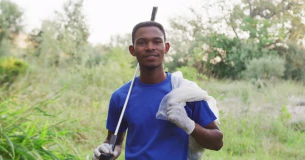 Portret Afroamerykanina Sprzątającego Rzekę Wsi Trzymającego Worek Śmieci Uśmiechającego Się — Wideo stockowe