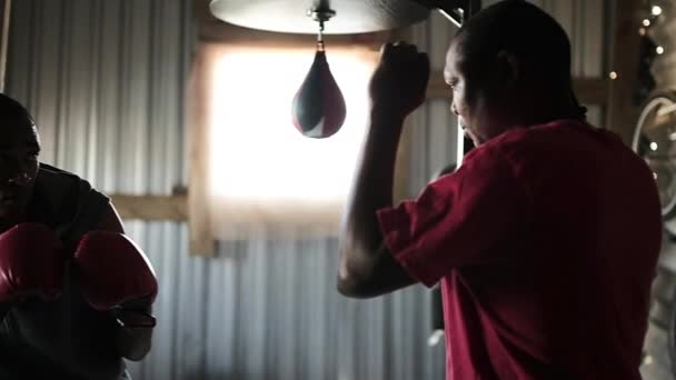 アフリカ系アメリカ人の男性のボクサーは スポーツ服やボクシンググローブのトレーニングを着ている町のボクシングジムスローパンチでアフリカ系アメリカ人男性トレーナーの手で スローモーションで — ストック動画