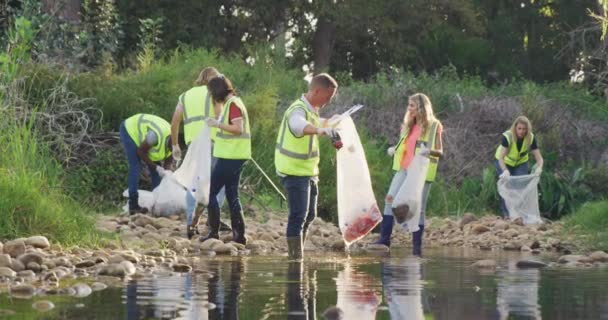 Multi Ethnic Group Conservation Volunteers Wearing Vis Vests Cleaning River — Stock Video