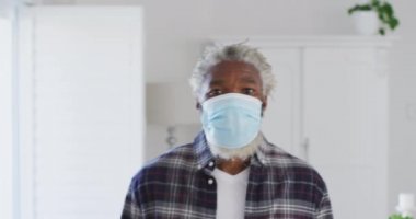 Beyaz saçlı ve sakallı, yüz maskesi takan Afro-Amerikan son sınıf öğrencisinin portresi. Coronavirus Covid 19 karantina sürecinde sosyal uzaklık ve kendini izole etme.