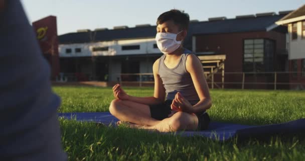 Garoto Caucasiano Usando Máscara Facial Meditando Jardim Escola Educação Primária — Vídeo de Stock