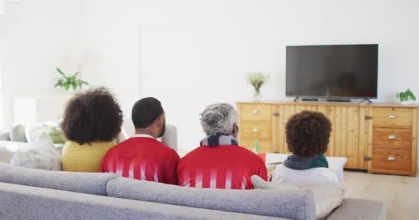 在家里的多代非裔美国人家庭坐在客厅的沙发上 看电视上的体育节目 全家人都在家里慢吞吞地度过美好时光 — 图库视频影像