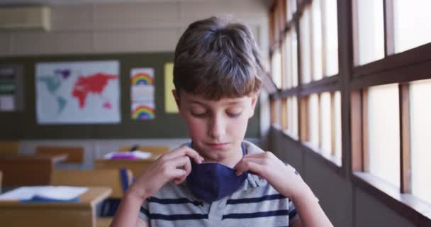 Blanke Jongen Met Een Gezichtsmasker Zittend Zijn Bureau School Kijkend — Stockvideo