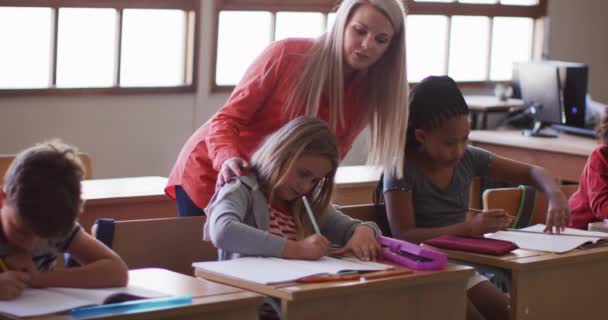Γυναίκα Δασκάλα Βοηθάει Μια Λευκή Κοπέλα Στην Τάξη Στο Σχολείο — Αρχείο Βίντεο