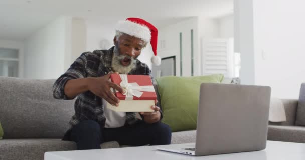 Uomo Anziano Afroamericano Casa Seduto Divano Soggiorno Aprendo Regalo Natale — Video Stock