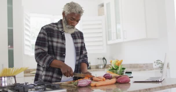 African American Senior Man Standing Kitchen Cutting Vegetables Knife Social — Stock Video