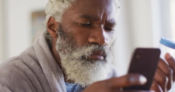 Старший Афроамериканец Сидит Столом Рассматривает Медицинские Пакеты Использует Смартфон Социальное — стоковое видео