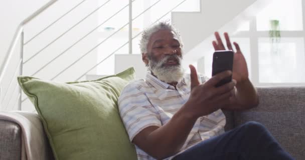Hombre Mayor Afroamericano Sentado Sofá Usando Teléfono Inteligente Distanciamiento Social — Vídeos de Stock