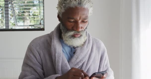 Hombre Mayor Afroamericano Pie Dormitorio Usando Teléfono Inteligente Estornudos Distanciamiento — Vídeos de Stock