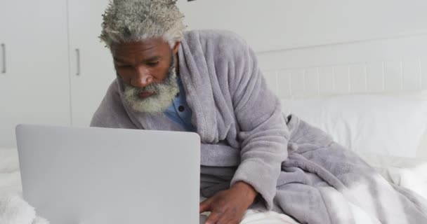 Старший Афроамериканец Лежит Кровати Спальне Используя Ноутбук Социальную Дистанцию Самоизоляцию — стоковое видео
