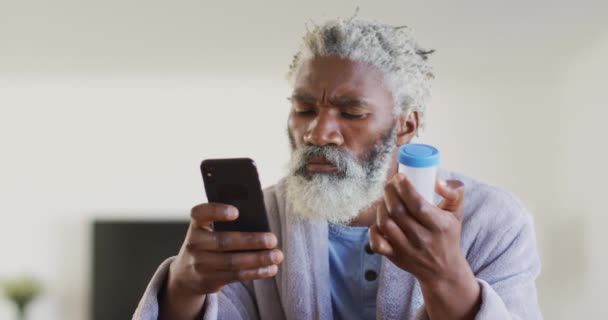 Hombre Mayor Afroamericano Sentado Junto Una Mesa Mirando Paquetes Medicamentos — Vídeos de Stock