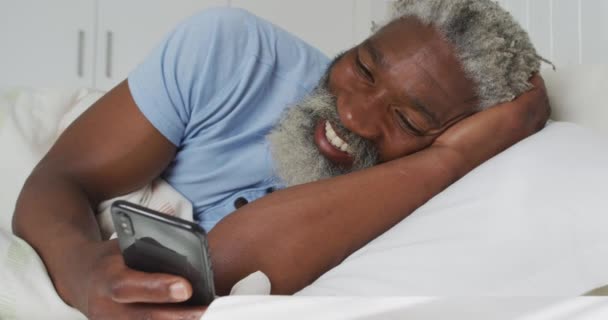 Hombre Mayor Afroamericano Acostado Una Cama Dormitorio Usando Teléfono Inteligente — Vídeos de Stock