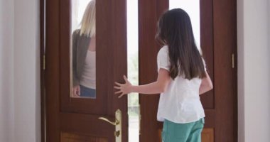 Beyaz kadın kızıyla birlikte yüz maskeleri takarak vakit geçiriyor. Kız annesini ağır çekimde selamlıyor. Covid 19 Coronavirus karantina süresince sosyal mesafeler.