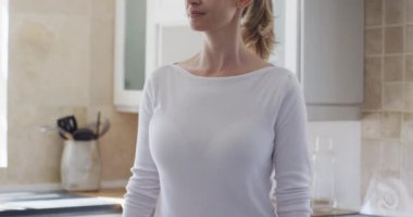 Beyaz bir kadın mutfakta, dirseğine hapşırıyor. Covid 19 Coronavirus karantinası sırasında evde tıbbi bakım, yavaş çekim.