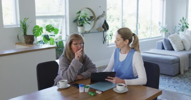 Senior Blanke Vrouw Thuis Bezocht Door Blanke Vrouwelijke Verpleegster Zitten — Stockvideo