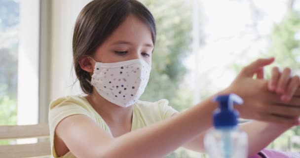 Chica Caucásica Casa Con Mascarilla Facial Desinfectando Sus Manos Cámara — Vídeo de stock