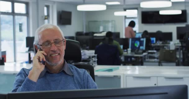 Белый Мужчина Работающий Обычном Офисе Сидящий Столом Компьютерами Разговаривающий Телефону — стоковое видео