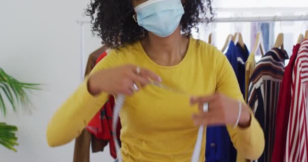 混合种族女性时装设计师的肖像 身穿面罩 脖子上缠着胶带 动作缓慢 Coronavirus Covid 19大流行病期间工作场所的健康和卫生 — 图库视频影像
