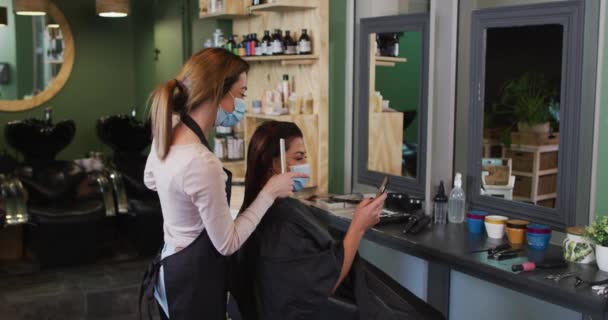 Peluquería Femenina Caucásica Trabajando Peluquería Con Mascarilla Facial Cepillando Cabello — Vídeos de Stock