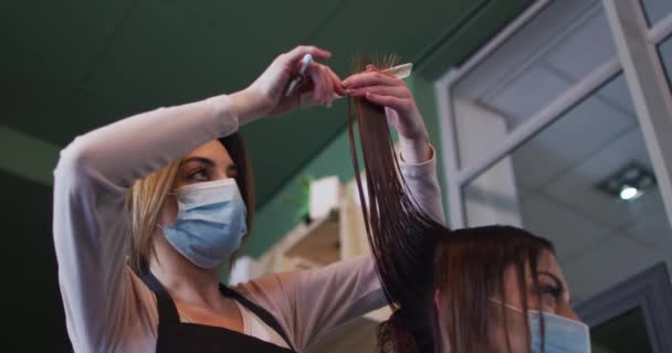 Biała Fryzjerka Pracująca Salonie Fryzjerskim Nosząca Maskę Twarzy Obcinająca Włosy — Wideo stockowe