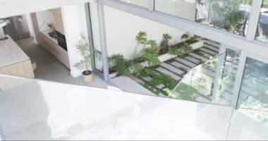 Mermer tezgahlı modern bir mutfak yemyeşil bahçeli küçük bir bahçeye bakıyor. Mekan, ev içi rahatlığı ile dışarıdaki tazeliği harmanlıyor ve huzurlu bir ev ortamı yaratıyor..