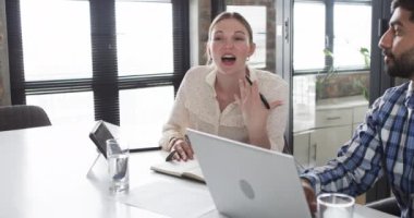 Beyaz bir kadın ve Asyalı bir adam iş görüşmesindeler. İş hakkında konuşurken el kol hareketi yapıyor, meslektaşına bir noktayı vurguluyor, ağır çekim..