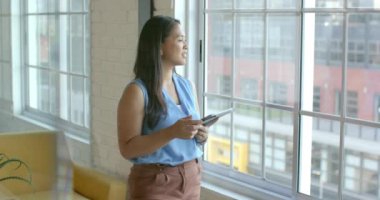 Çift ırklı bir kadın, parlak bir ofiste bir iş sorunu üzerine kafa yorar. Elinde bir tablet var, profesyonel bir ortamda yavaş çekimde bir anlık tefekkür izlenimi veriyor..