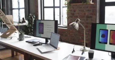 Modern iş alanı bir dizüstü bilgisayar, iki monitör ve çeşitli ofis malzemeleri ile donatılmıştır. Ayarlar, yaratıcı ya da teknoloji odaklı bir profesyonel ortam, bir tasarım stüdyosu olduğunu gösteriyor..