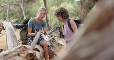 Ormanlık bir alanda yürüyüş sırasında iki genç kadın sohbet ediyorlar. Sarışın beyaz kadın akıllı bir telefon tutarken kıvırcık saçlı melez kadın ise açık hava kıyafetleri giyen bir kamera taşıyor..